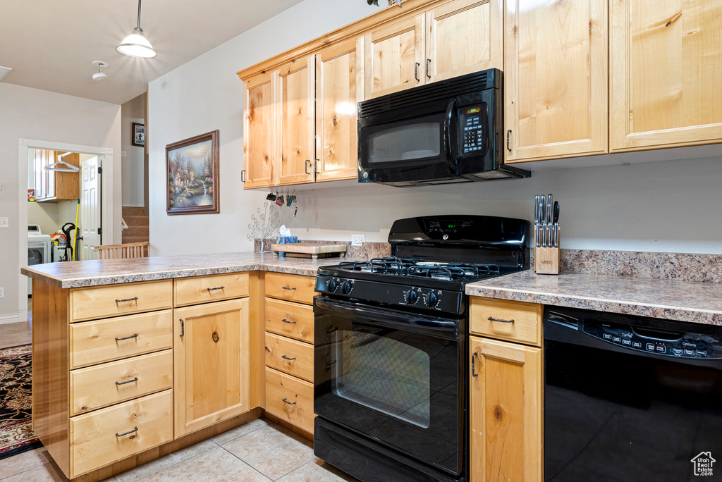 Kitchen featuring light tile floors, light brown cabinetry, black appliances, kitchen peninsula, and pendant lighting