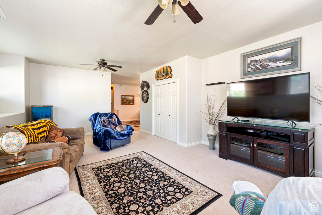 Living room featuring light colored carpet and ceiling fan