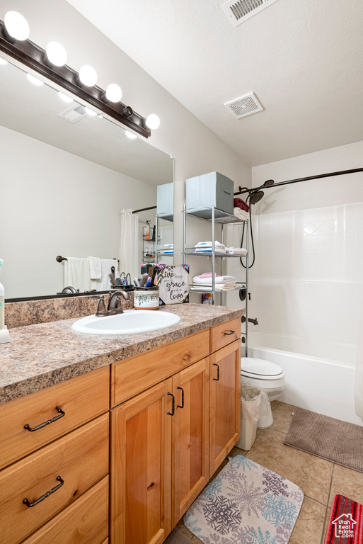 Full bathroom with shower / bath combination with curtain, tile flooring, vanity, and toilet