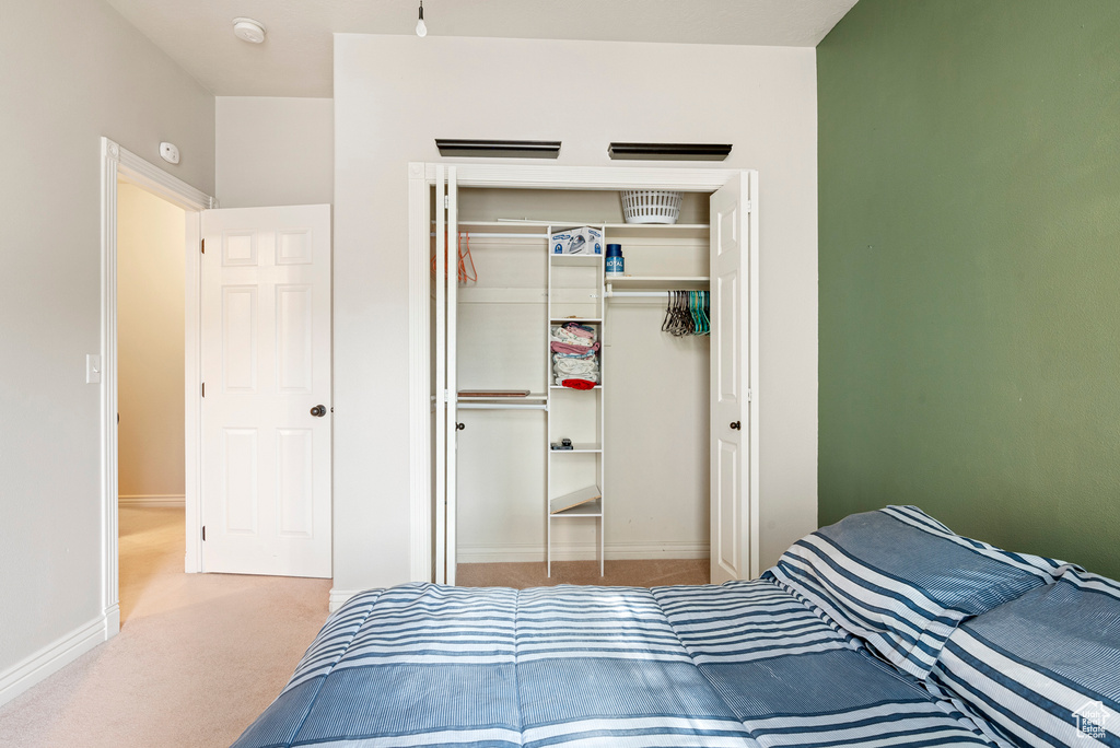 Carpeted bedroom featuring a closet