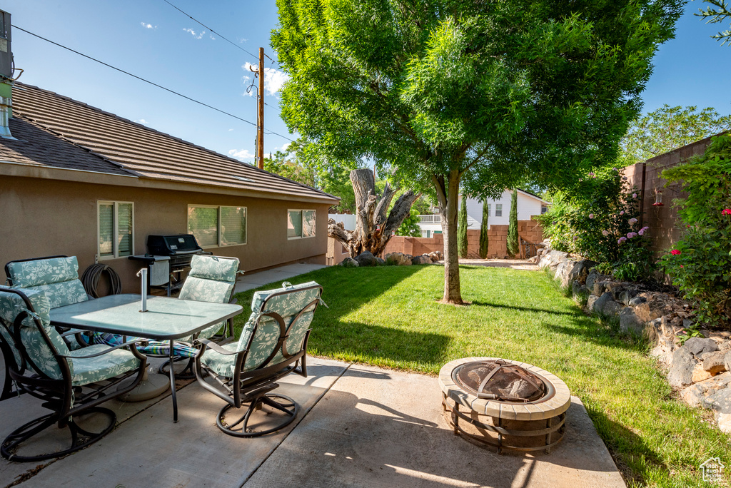 View of terrace with an outdoor fire pit and a grill