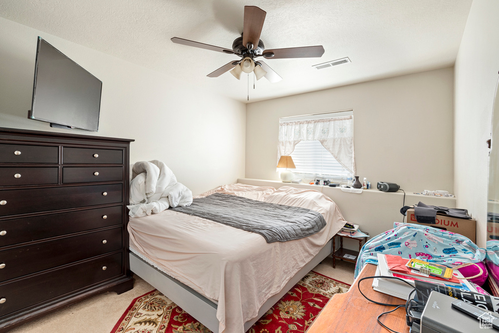 Carpeted bedroom featuring ceiling fan