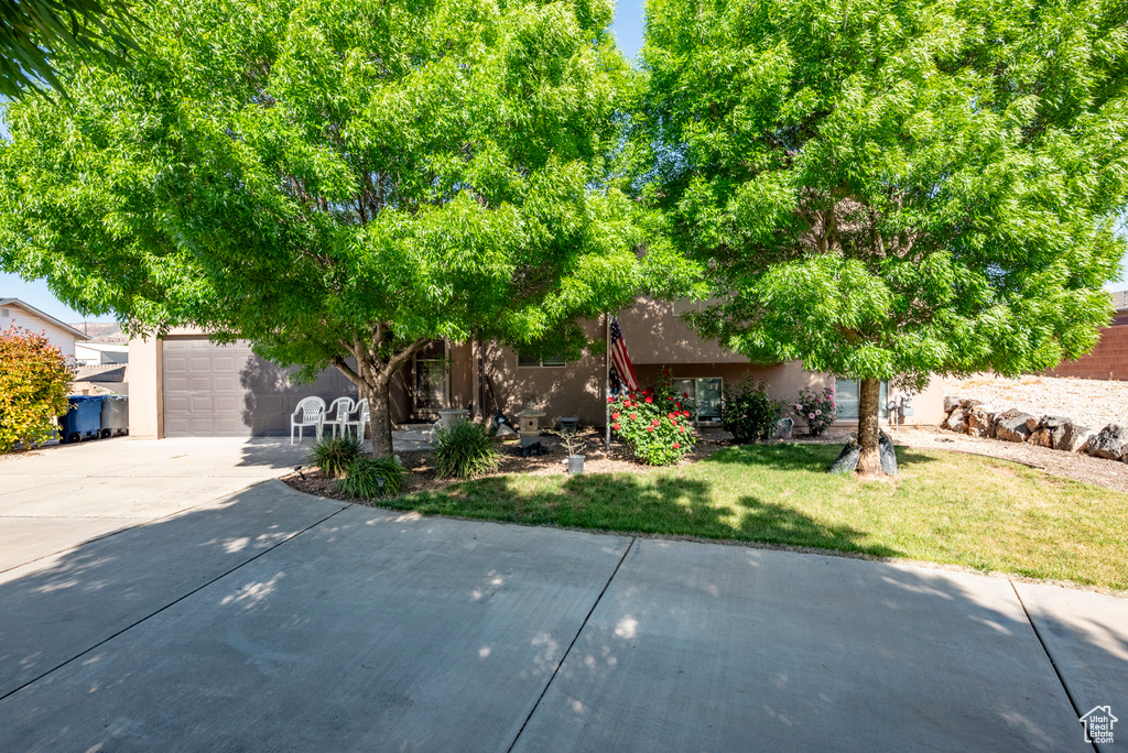 View of front facade featuring a front yard and a garage