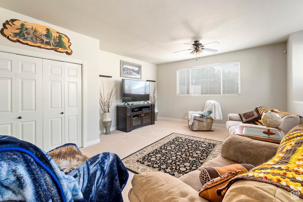 Carpeted living room with ceiling fan