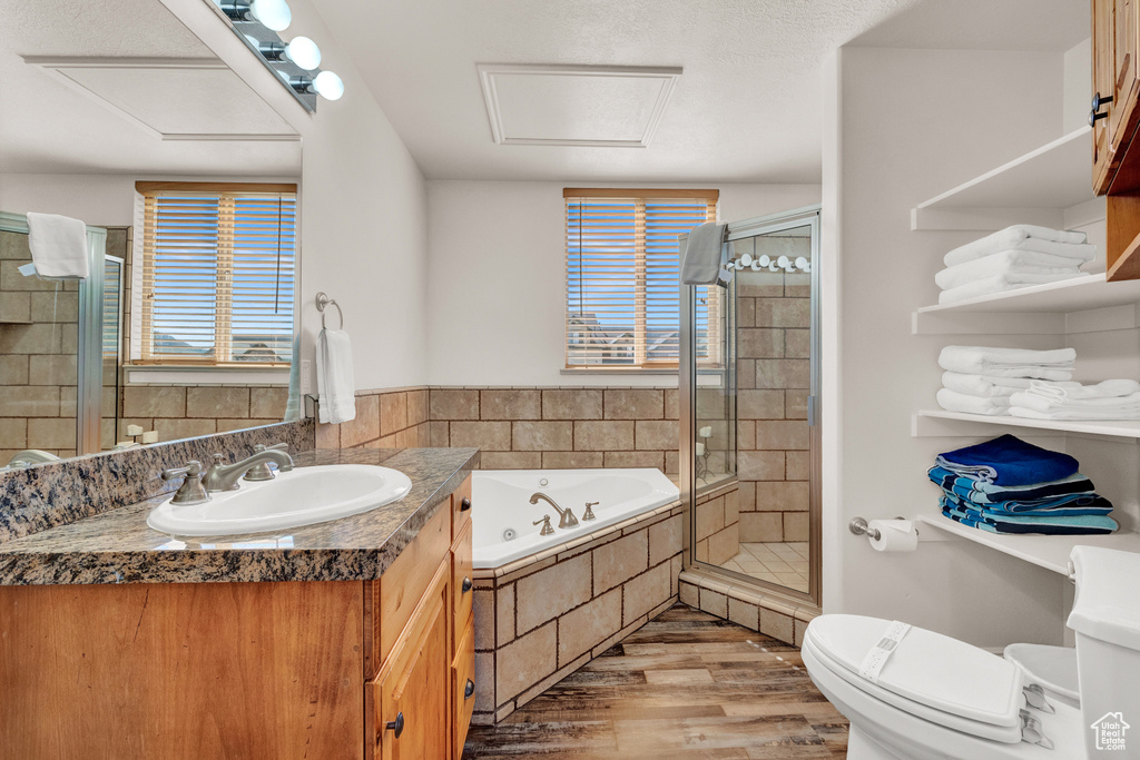 Full bathroom featuring hardwood / wood-style floors, oversized vanity, toilet, and plus walk in shower