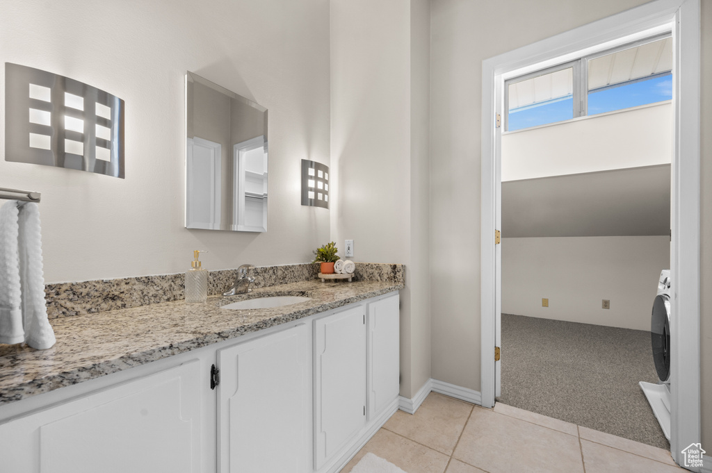 Bathroom featuring vanity, washer / dryer, and tile flooring