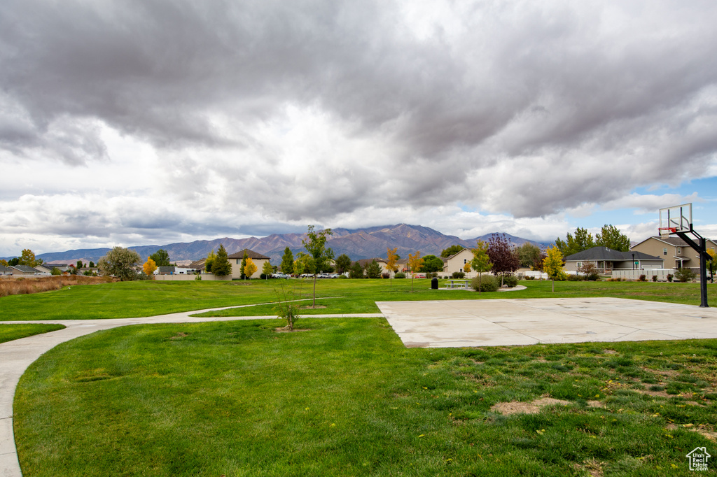 View of yard with a mountain view and basketball hoop