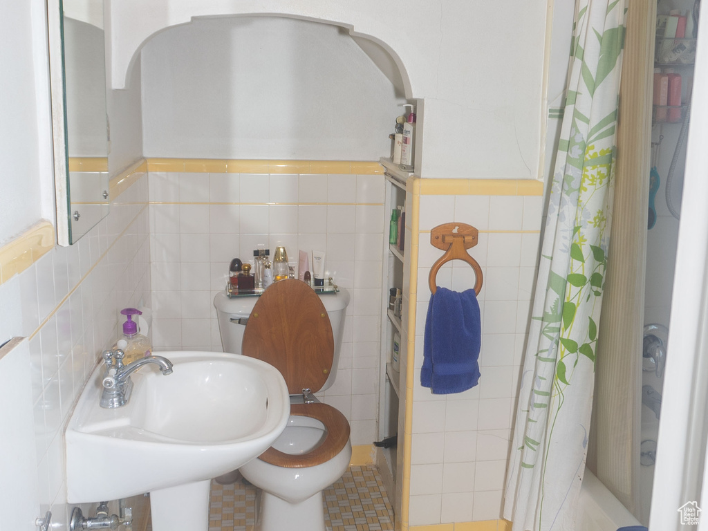 Bathroom with backsplash, tile walls, toilet, and tile flooring