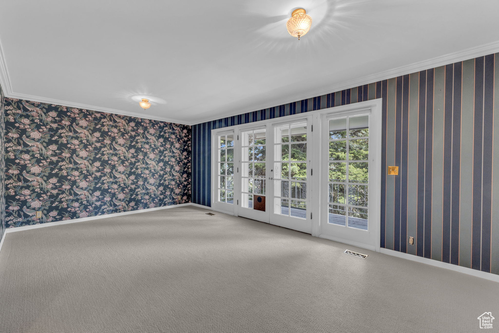 Spare room featuring carpet, french doors, and crown molding