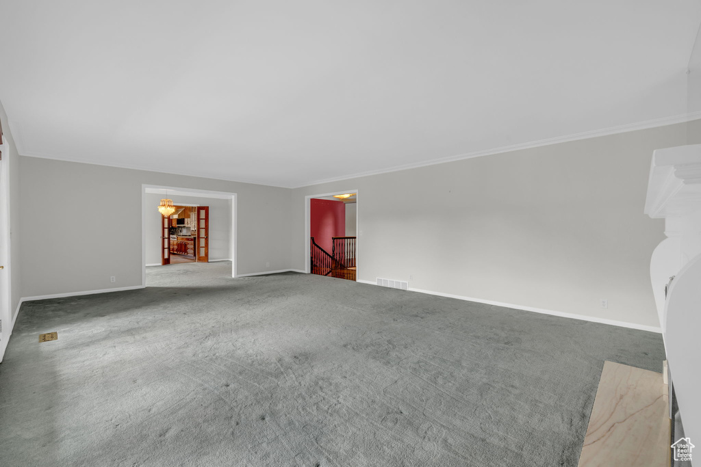 Carpeted spare room with crown molding