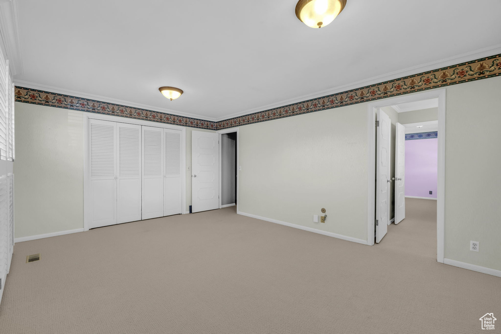 Interior space with crown molding and carpet floors