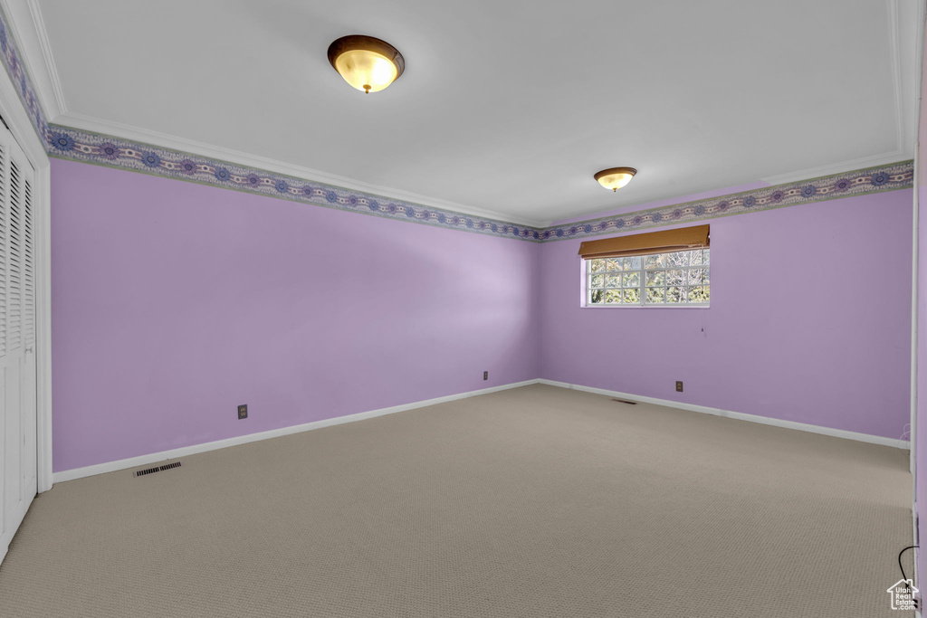 Empty room with carpet and ornamental molding