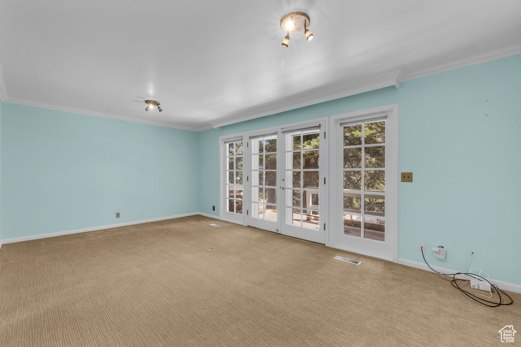 Unfurnished room with french doors, carpet flooring, and ornamental molding