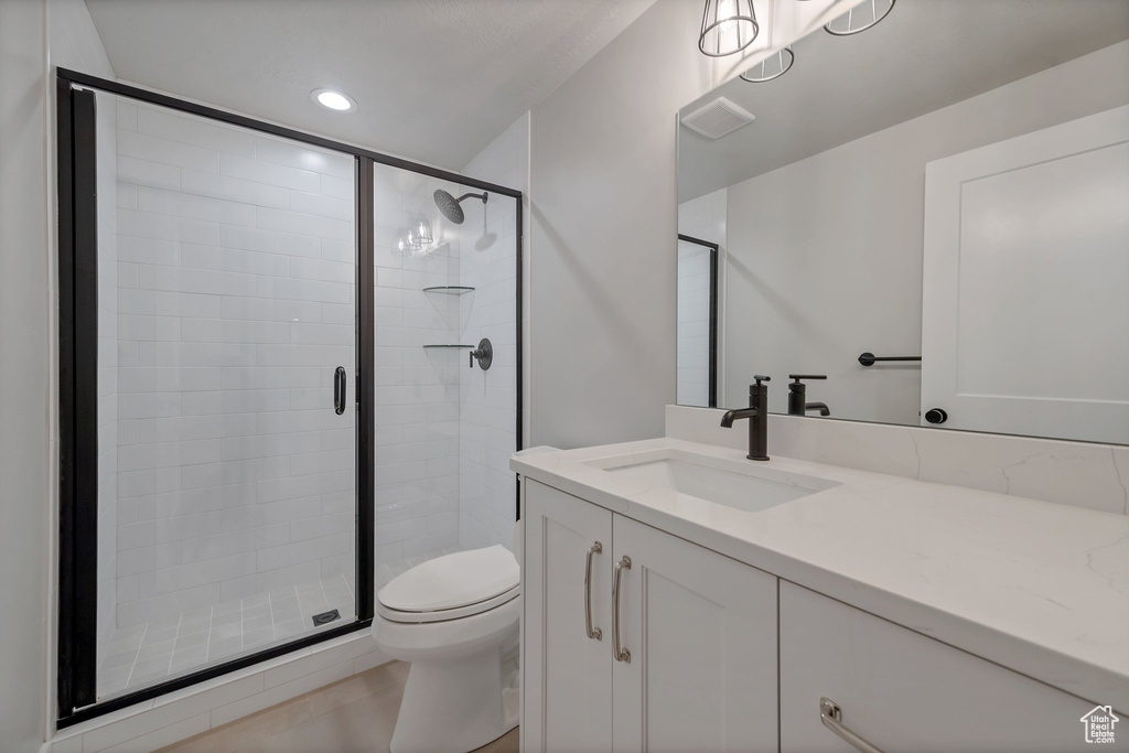 Bathroom featuring large vanity, an enclosed shower, tile floors, and toilet