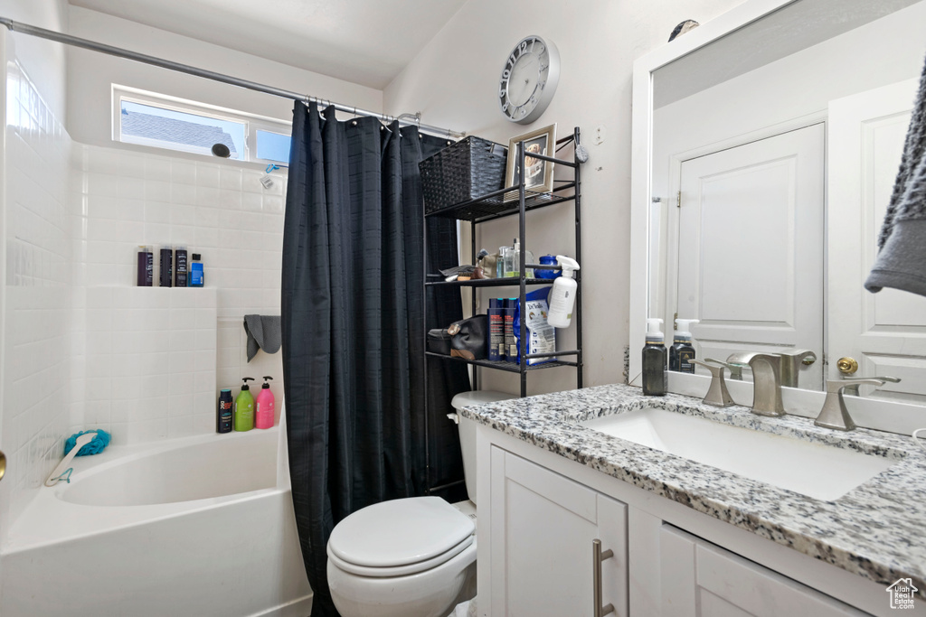 Full bathroom featuring vanity, shower / bath combination with curtain, and toilet