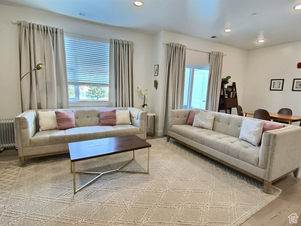 Living room with hardwood / wood-style flooring and radiator