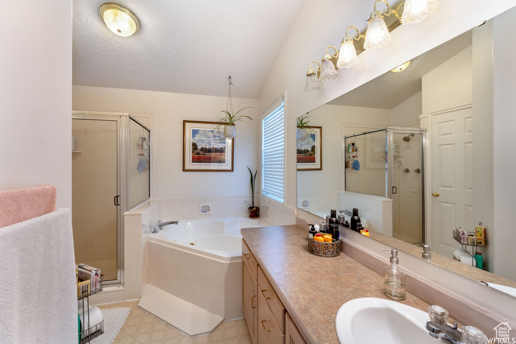 Bathroom featuring double sink vanity, separate shower and tub, and tile floors