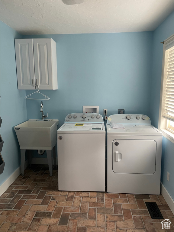 Clothes washing area with hookup for an electric dryer, cabinets, and washing machine and clothes dryer