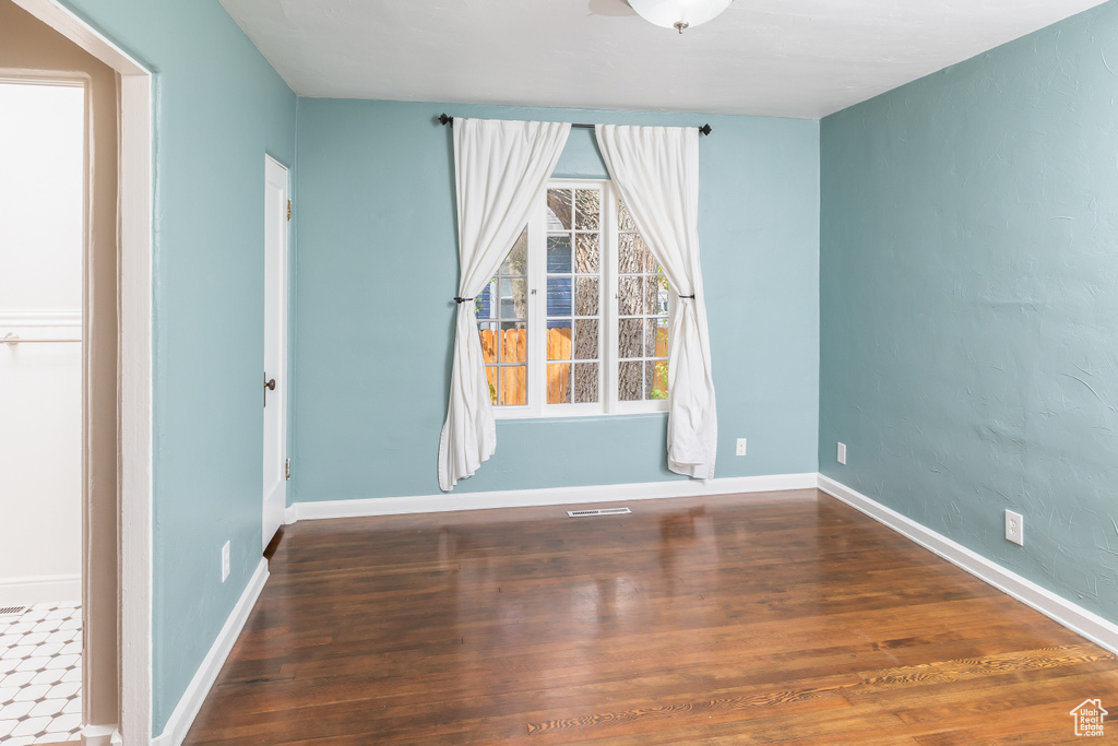 Unfurnished room with a healthy amount of sunlight and hardwood / wood-style floors