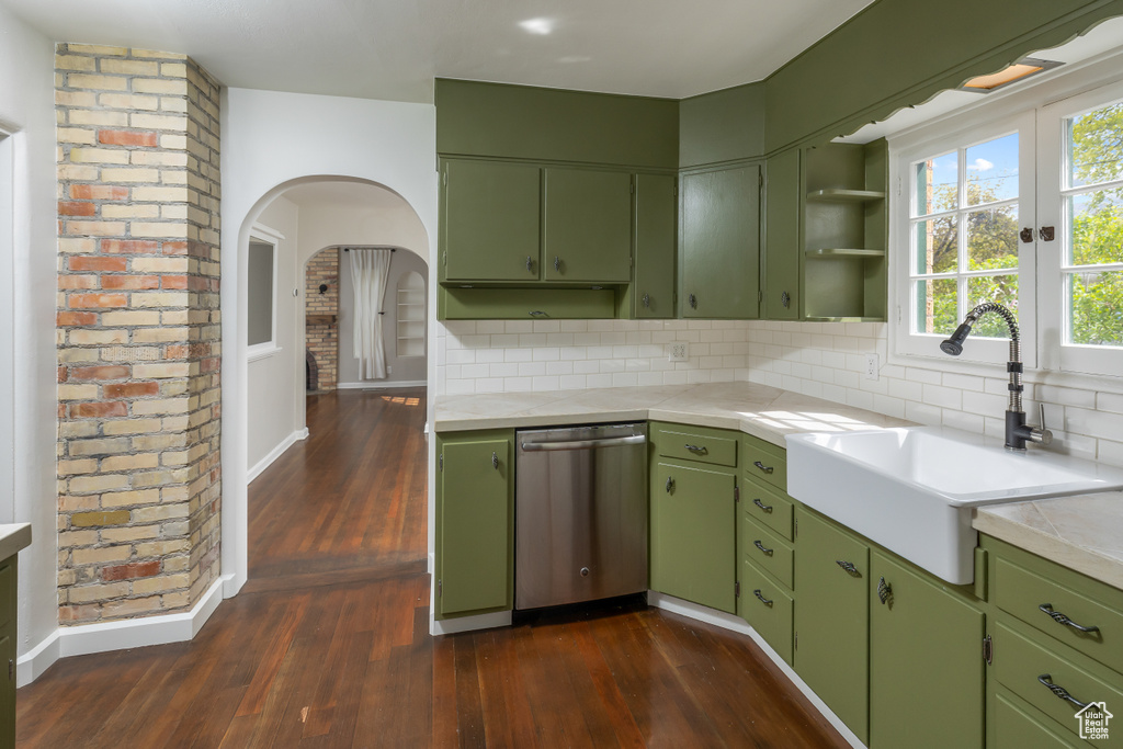 Kitchen with dark hardwood / wood-style flooring, dishwasher, and backsplash
