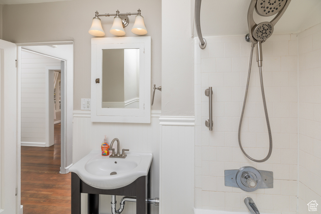 Bathroom featuring wood-type flooring, vanity, and tiled shower / bath