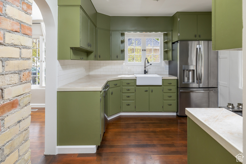 Kitchen featuring tasteful backsplash, dark wood-type flooring, stainless steel appliances, and sink