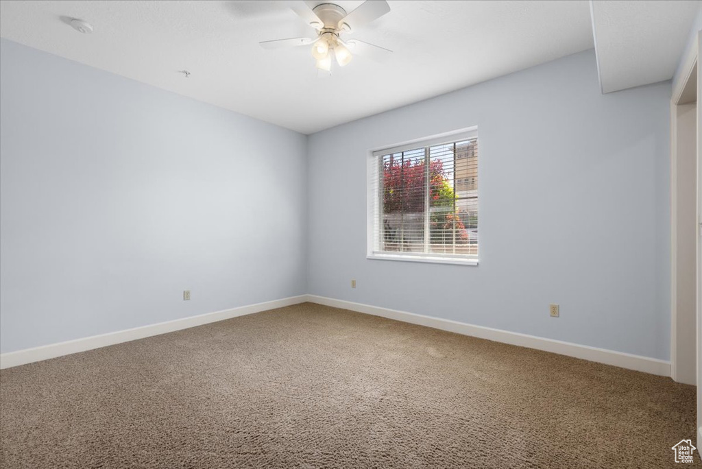 Unfurnished room with ceiling fan and carpet flooring