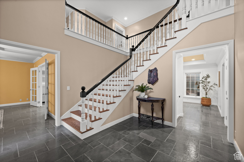 Stairs featuring dark tile flooring and a high ceiling