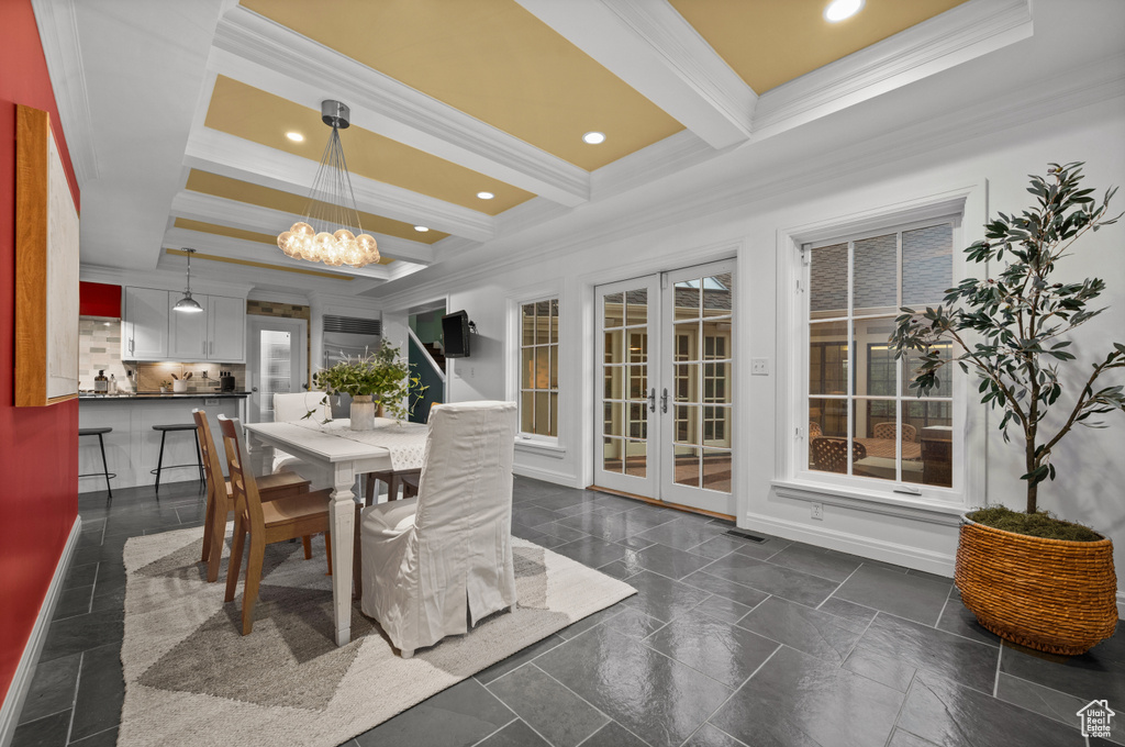 Tiled dining space featuring ornamental molding, french doors, beam ceiling, and an inviting chandelier