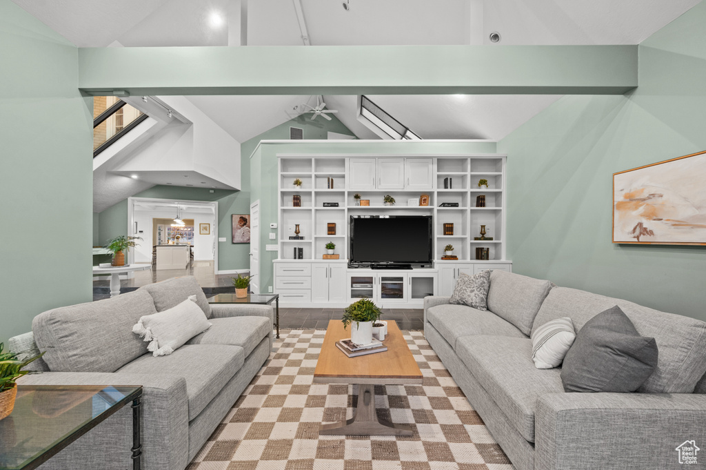 Living room with high vaulted ceiling, beam ceiling, and ceiling fan