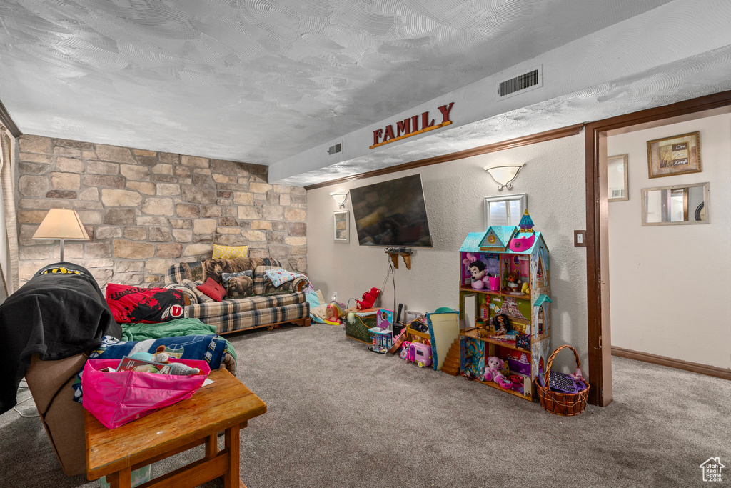 Playroom featuring carpet and a textured ceiling
