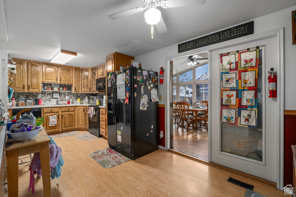 Kitchen featuring ceiling fan, sink, light tile flooring, tasteful backsplash, and black appliances