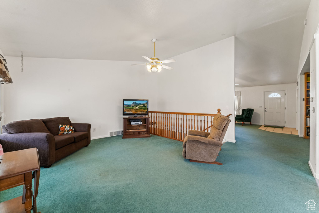 Living room featuring carpet flooring, ceiling fan, and vaulted ceiling