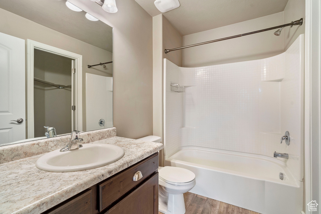 Full bathroom with shower / bathing tub combination, vanity, hardwood / wood-style flooring, and toilet