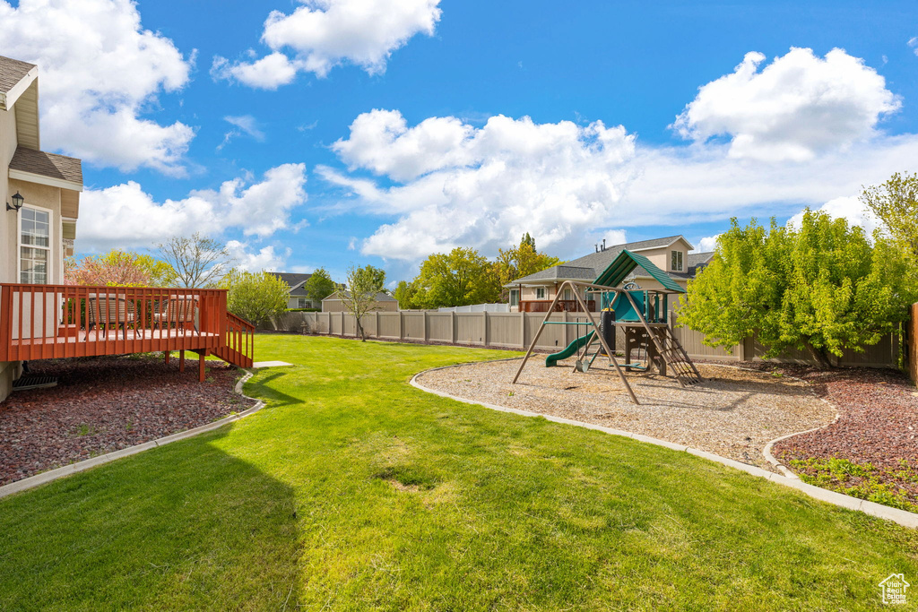 View of yard featuring a playground and a wooden deck