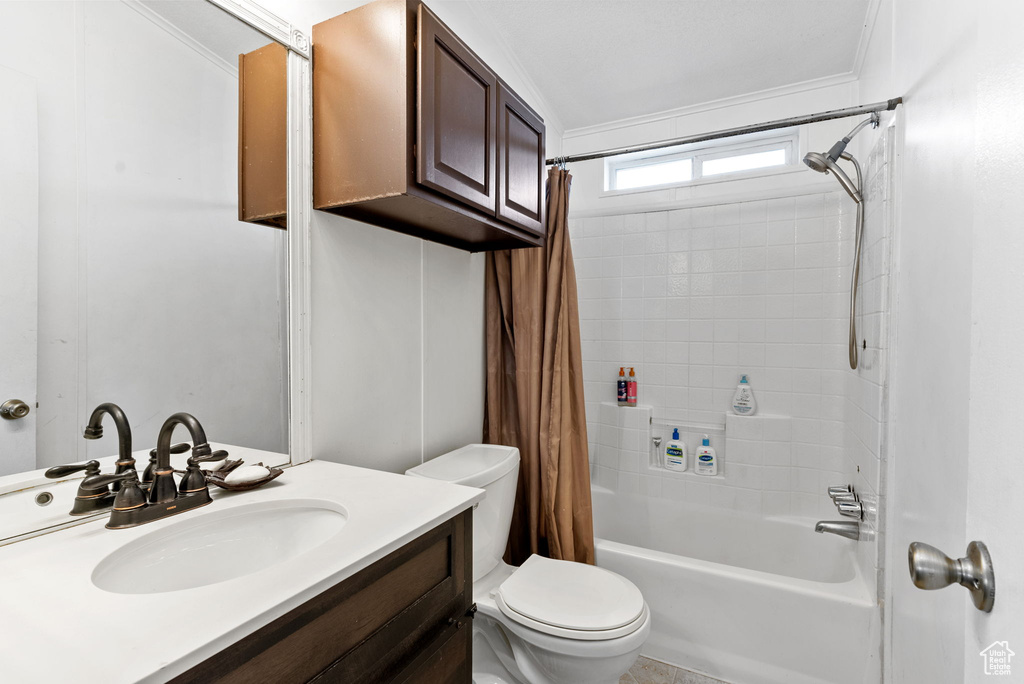 Full bathroom featuring oversized vanity, shower / bathtub combination with curtain, crown molding, and toilet