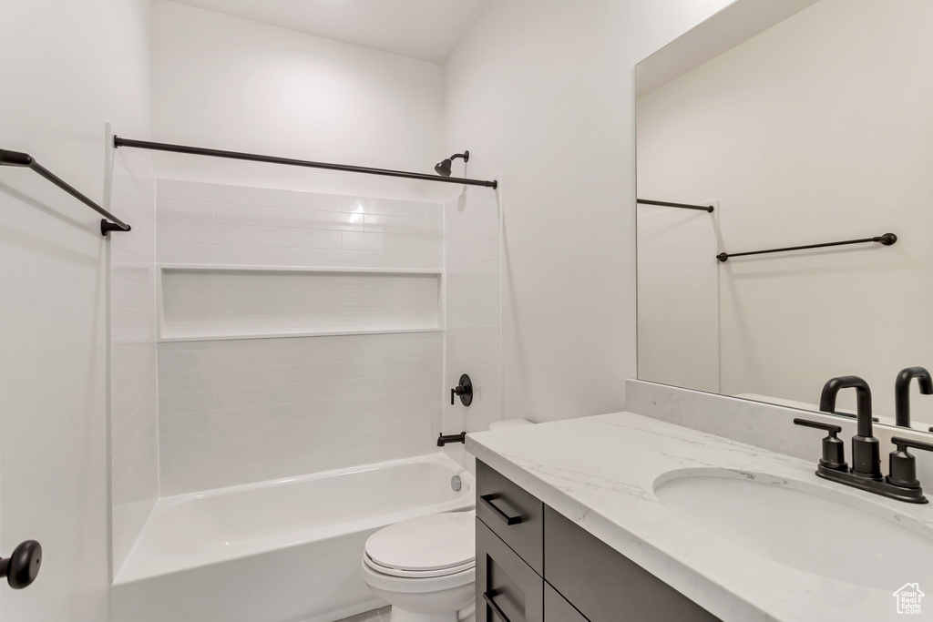Full bathroom featuring washtub / shower combination, oversized vanity, and toilet