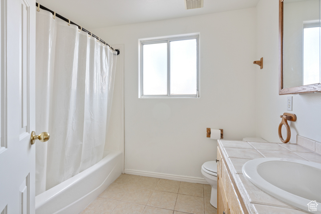 Full bathroom featuring plenty of natural light, toilet, tile flooring, and vanity