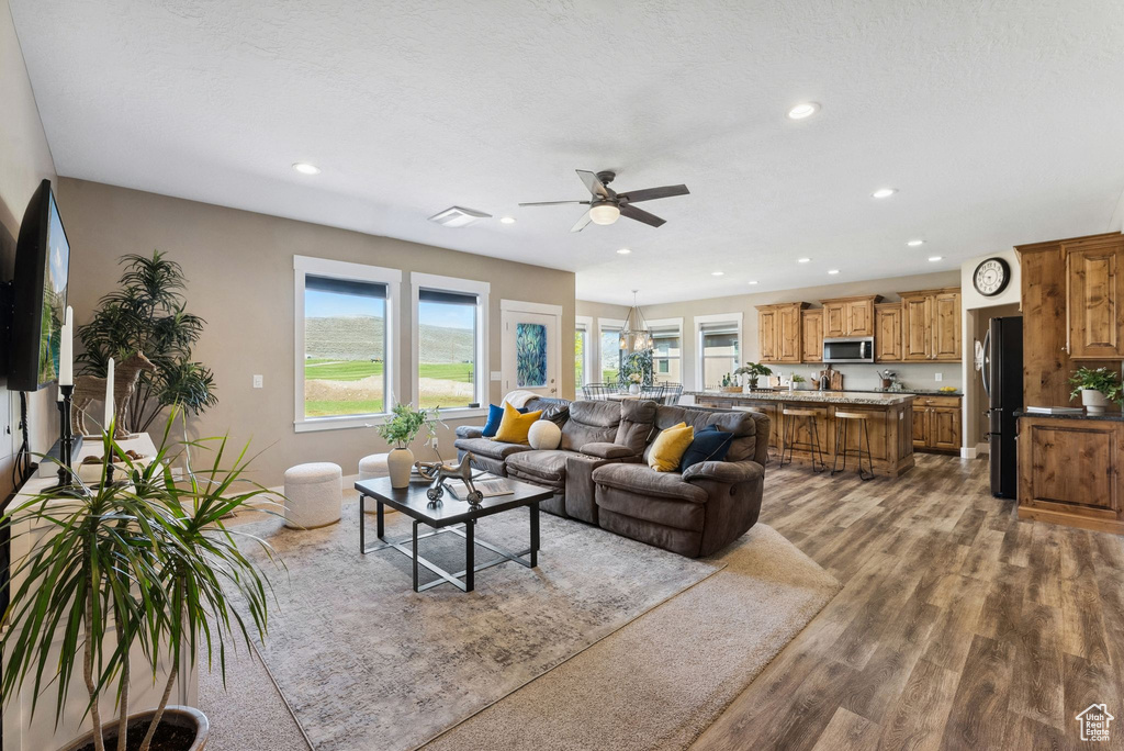 Living room with wood-type flooring and ceiling fan