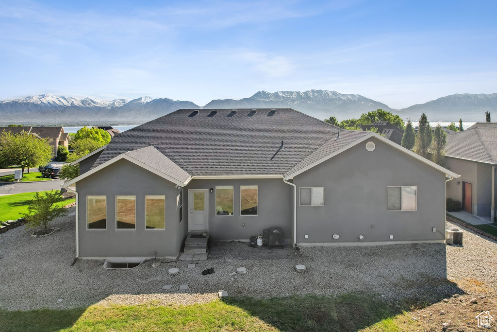 Back of property with central AC and a mountain view