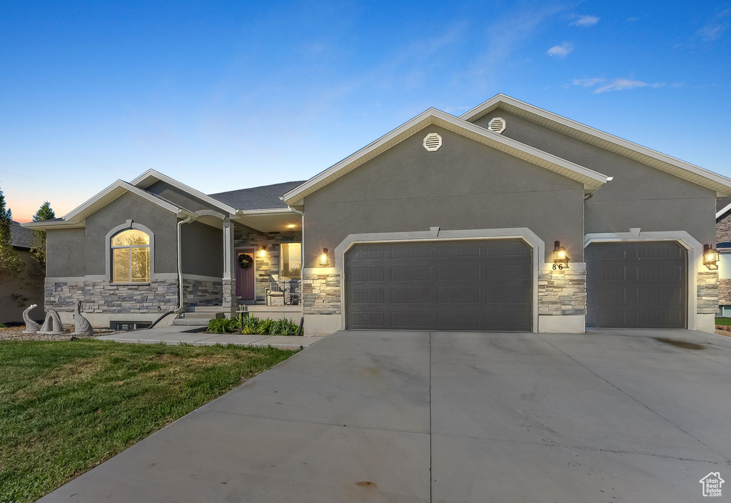 Ranch-style home with a garage and a yard