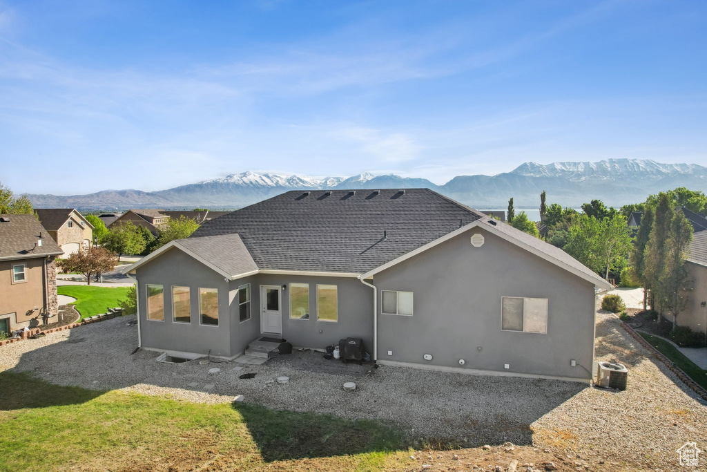 Back of house with central AC unit and a mountain view