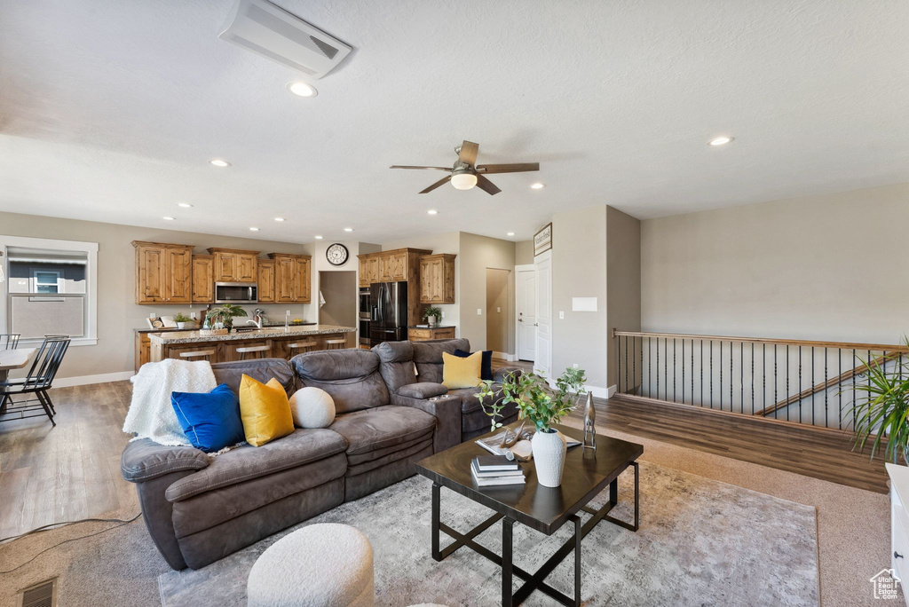 Living room with light wood-type flooring and ceiling fan