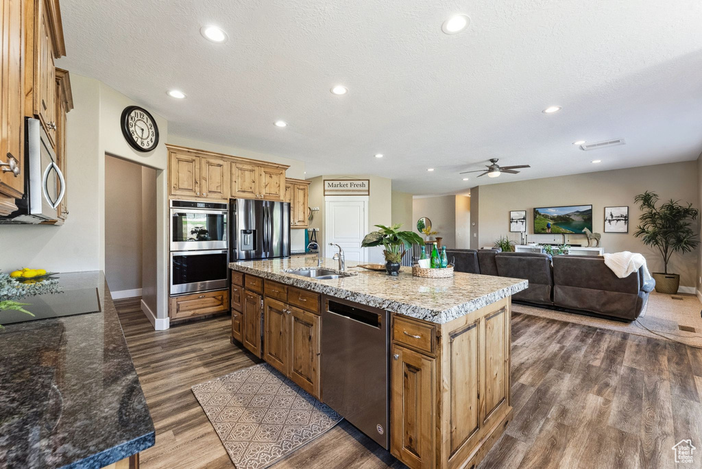 Kitchen with a center island with sink, ceiling fan, hardwood / wood-style flooring, sink, and appliances with stainless steel finishes