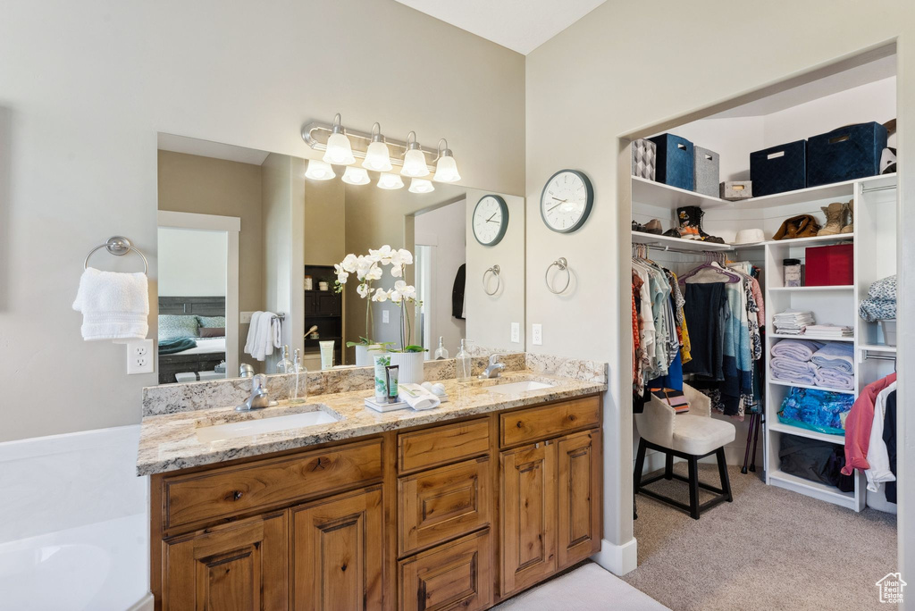 Bathroom featuring double sink vanity and a bathing tub