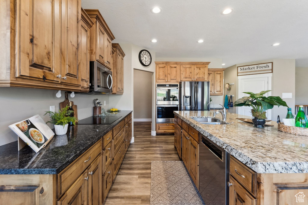 Kitchen featuring a center island with sink, light hardwood / wood-style floors, and appliances with stainless steel finishes