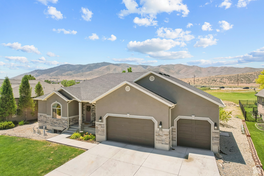 Ranch-style house featuring a garage, a mountain view, and a front yard