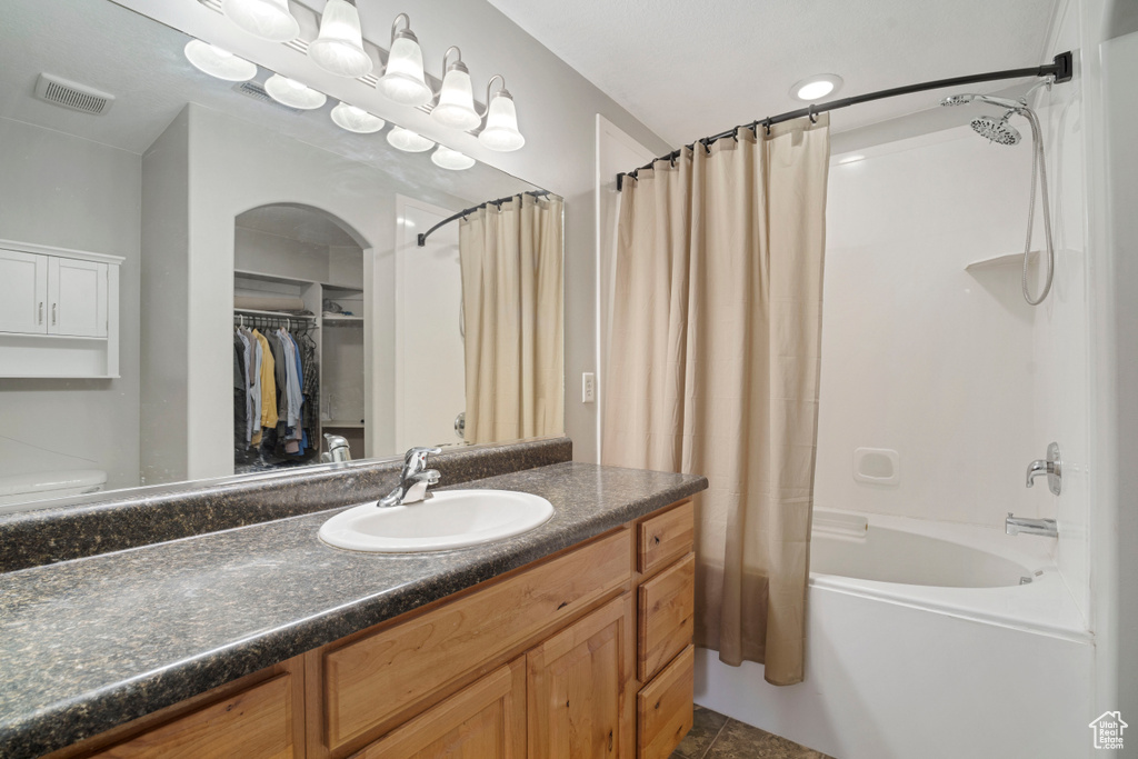 Bathroom with shower / tub combo, oversized vanity, and tile flooring