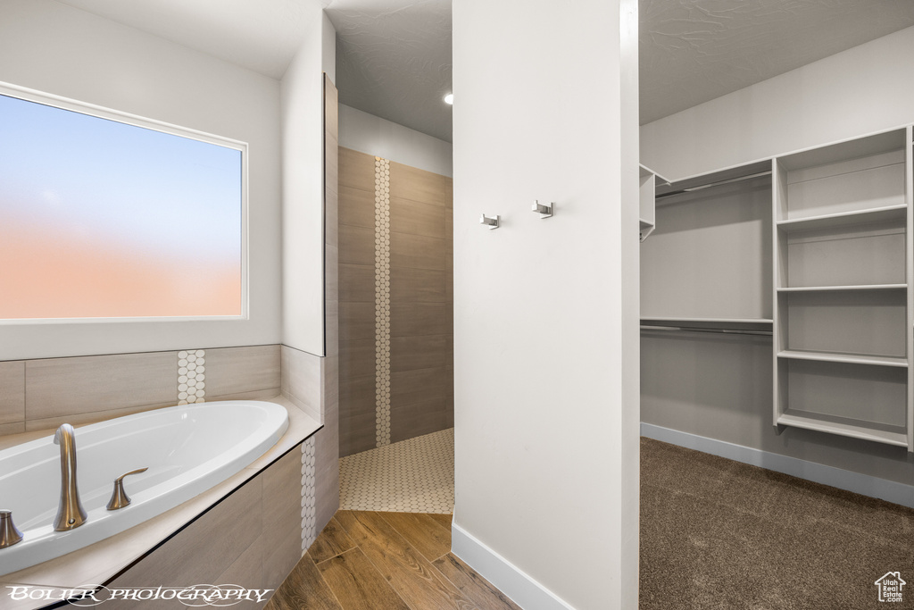 Bathroom featuring hardwood / wood-style flooring and independent shower and bath
