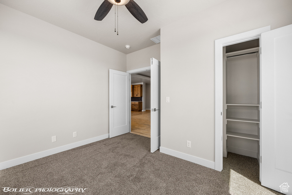 Unfurnished bedroom featuring ceiling fan and carpet flooring